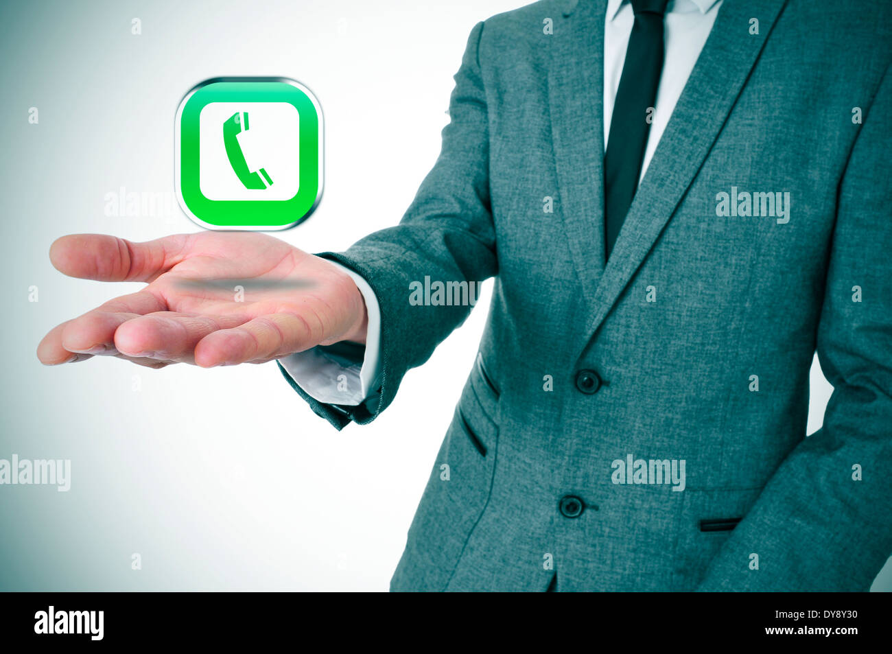 Un imprenditore con un'icona a forma di telefono nella sua mano raffigurante il voice-over-IP APP Foto Stock