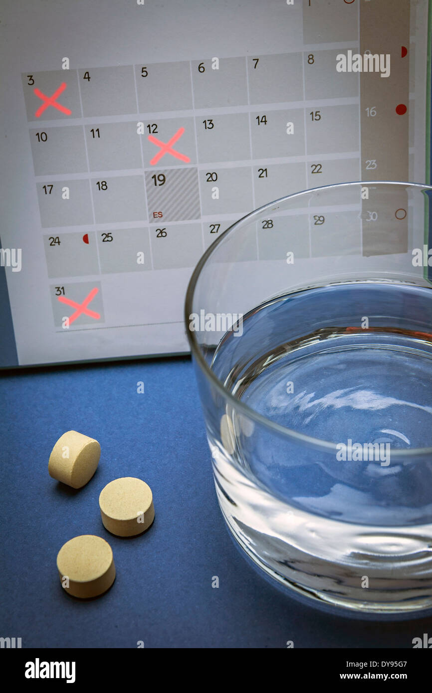 Pillole di controllo su un calendario Foto Stock