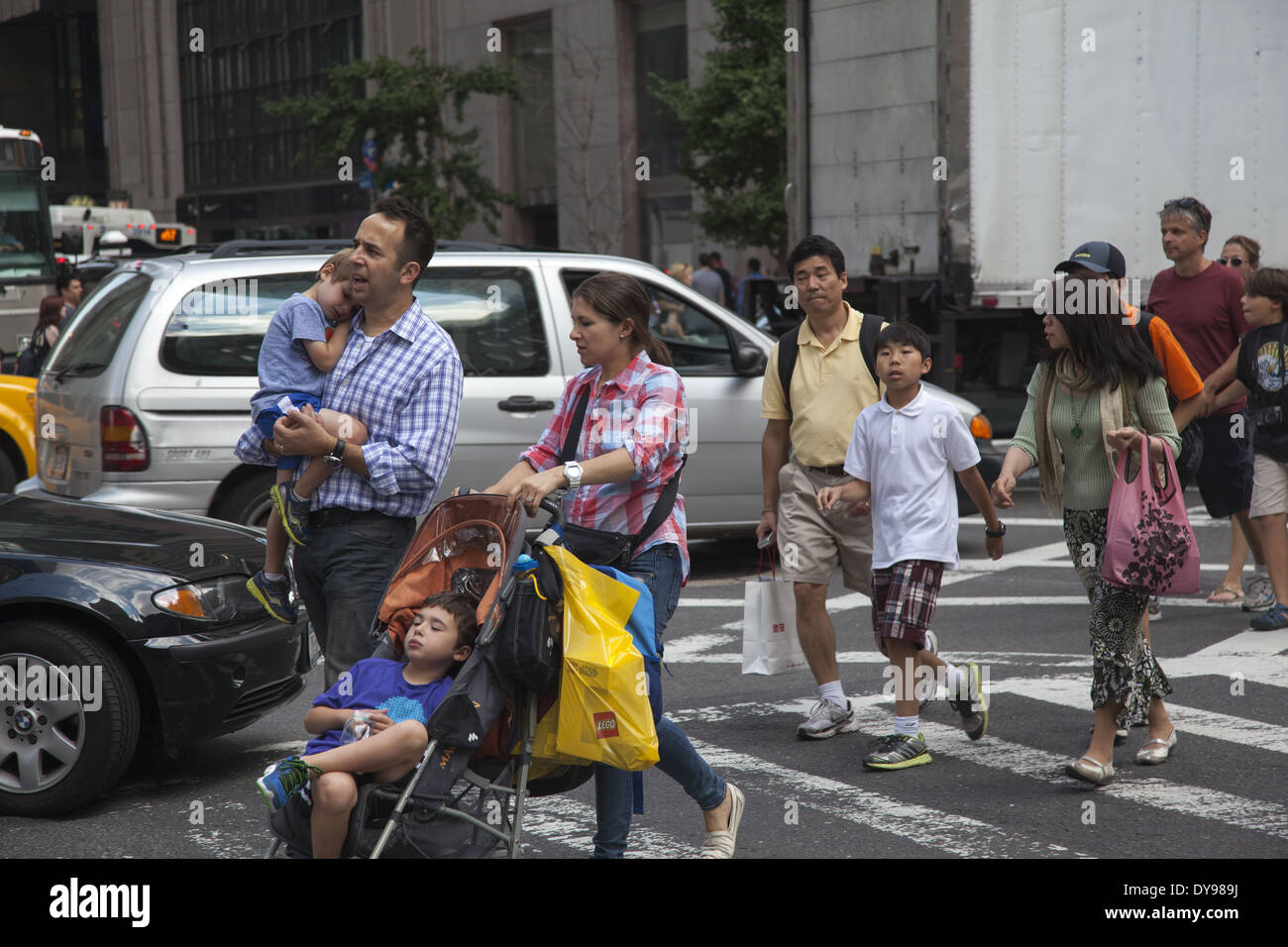 Le famiglie di shopping in croce di Manhattan 5th Ave. a 57th Street, New York. Foto Stock