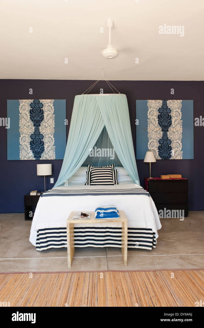 Letto matrimoniale con baldacchino netto in blu camera da letto murato con abbinamento di Floral stampare le foto Foto Stock