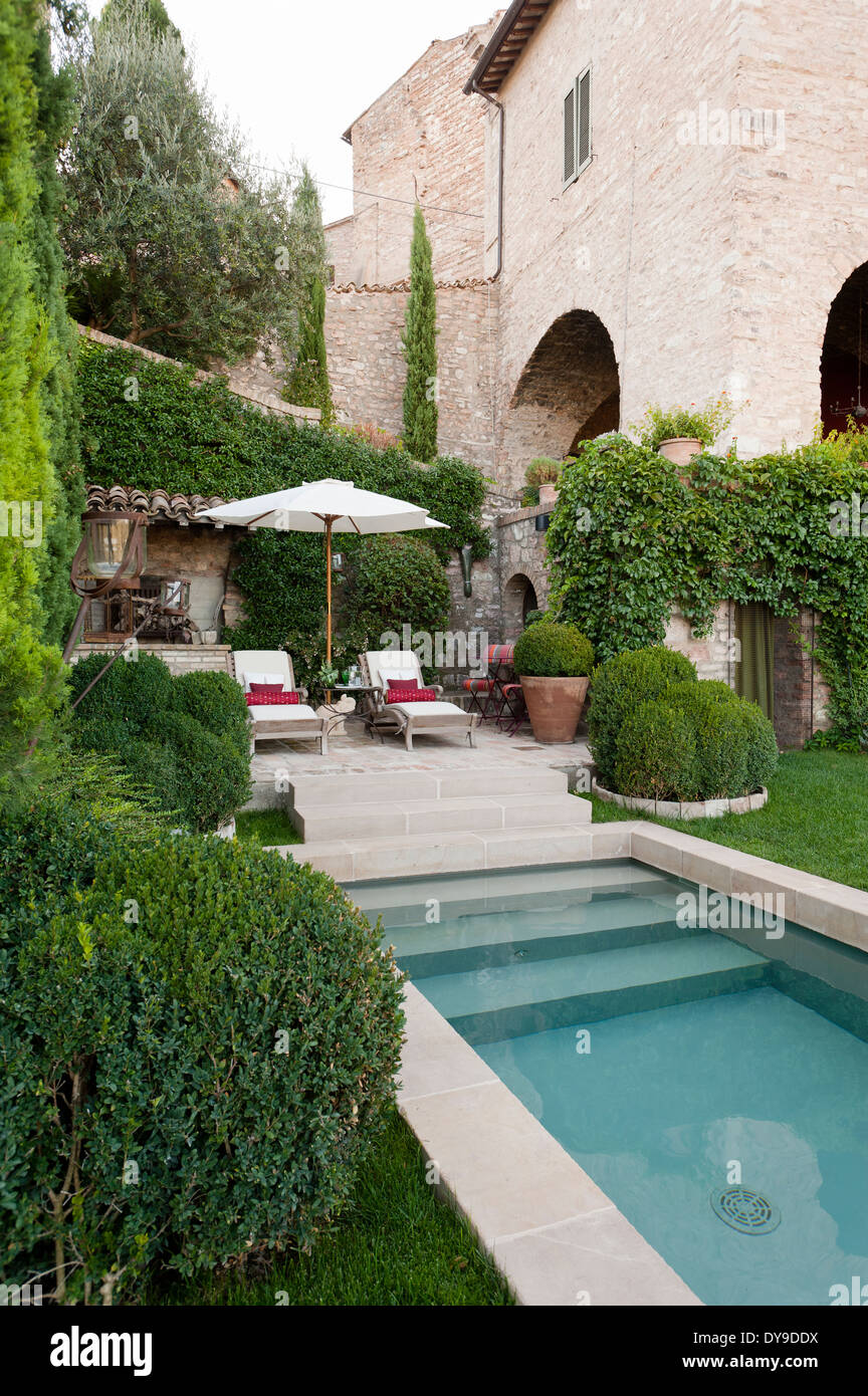 Piscina esterna e sedie a sdraio nel giardino di una vecchia villa Umbra Foto Stock