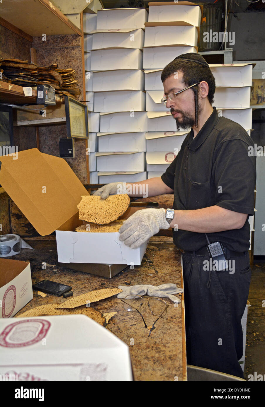 Un uomo che lavora presso il Parco di Borough Matzah panificio a Brooklyn, New York il confezionamento di pasqua Shmura pane azzimo Foto Stock