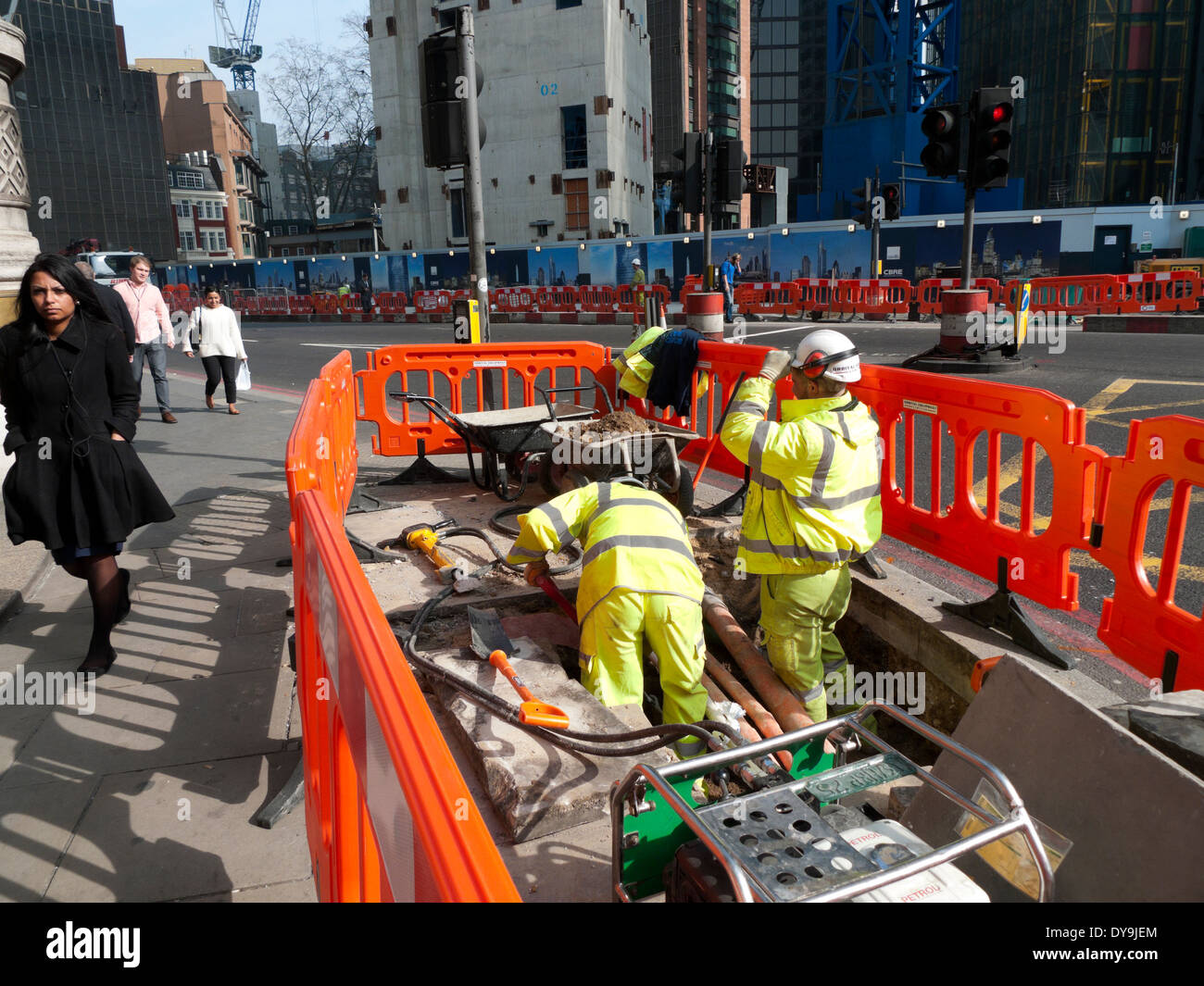 Lavori stradali e i lavoratori stradali posa tubi cavi con barriere all'angolo di Bishopsgate e Threadneedle Street nel centro di Londra UK KATHY DEWITT Foto Stock