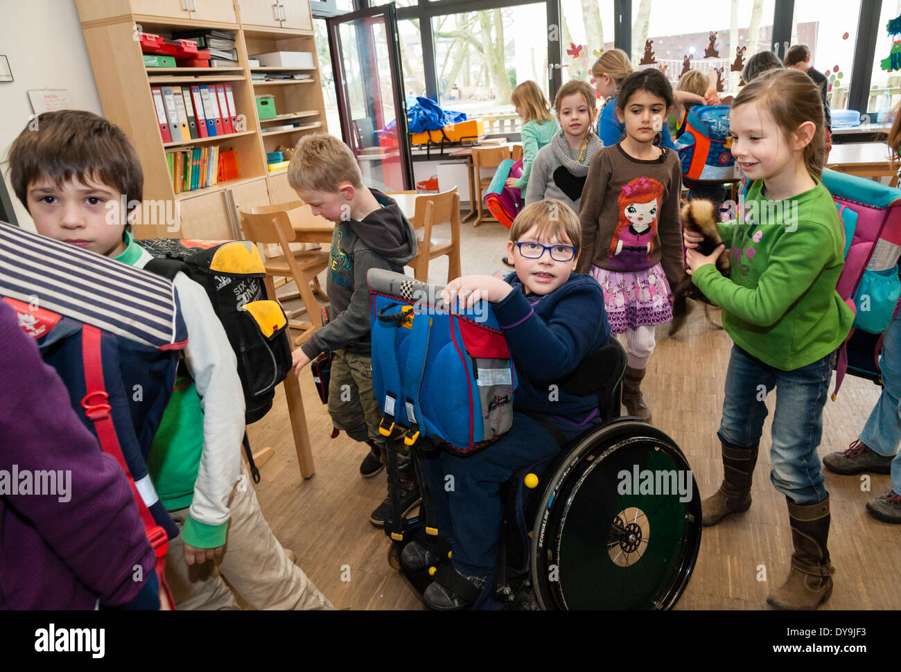Non-disabili e gli studenti disabili (in questo caso un ragazzo su una sedia a rotelle) imparare insieme nella stessa classe in una scuola primaria. Foto Stock