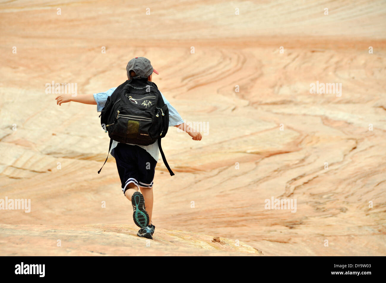 Bambino in esecuzione su pietra arenaria nel Parco Nazionale di Zion, Utah. Foto Stock