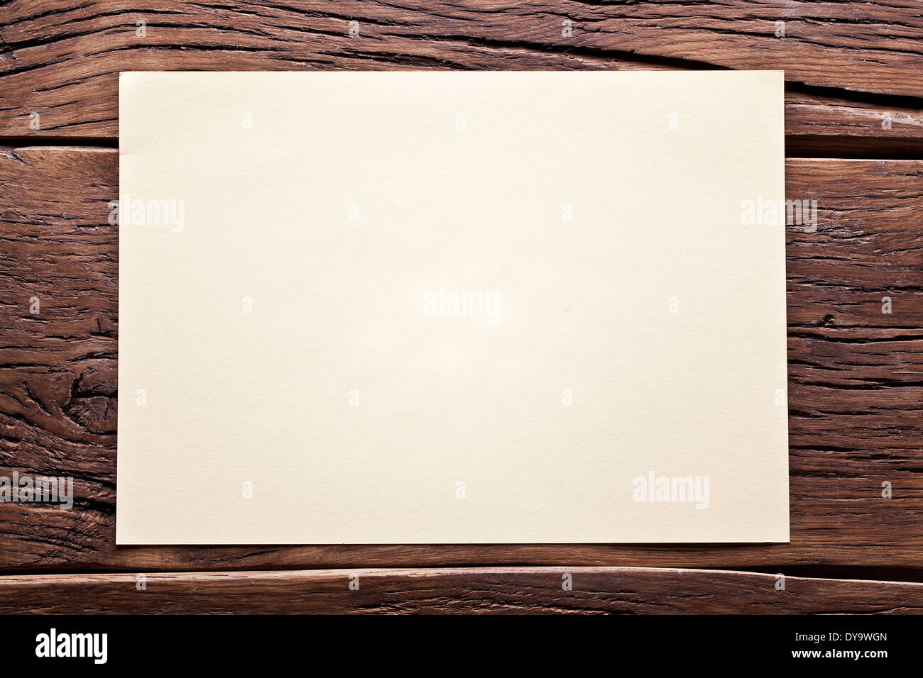 Foglio di carta bianco sul vecchio tavolo in legno. Foto Stock