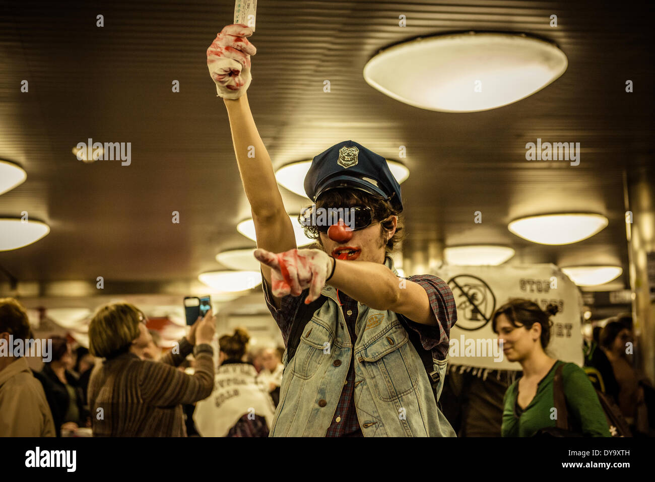 Barcellona, Spagna. Aprile 10th, 2014: Un attivista con un clown naso e polizia hat detiene un biglietto della metropolitana durante una manifestazione di protesta contro la tariffa sollevata per Barcellona il trasporto pubblico credito: matthi/Alamy Live News Foto Stock