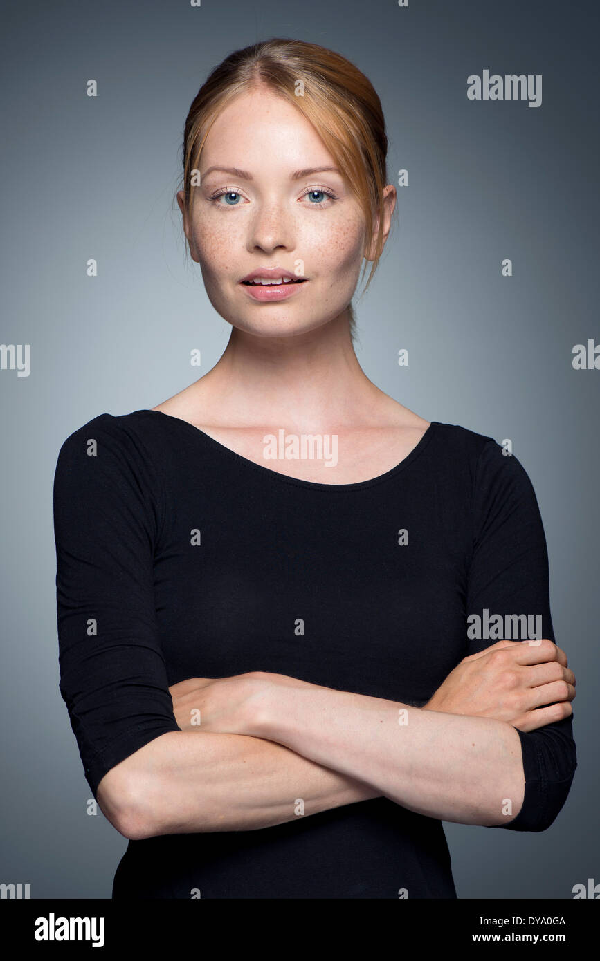 Giovane donna con le braccia incrociate, ritratto Foto Stock
