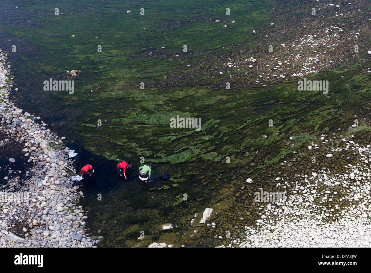 Donne vestiti in abiti tradizionali lavora con tessuti colorati sulla banca del fiume Duliu in Congjiang, Guizhou, Cina Foto Stock