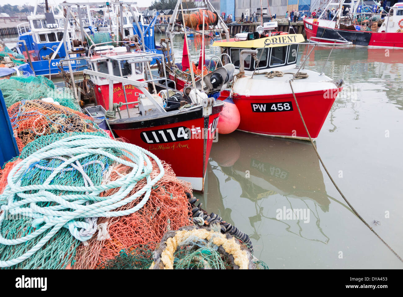 Regno Unito, Inghilterra, Whitstable. Le reti da pesca e le navi per la pesca a strascico ormeggiata in porto Foto Stock