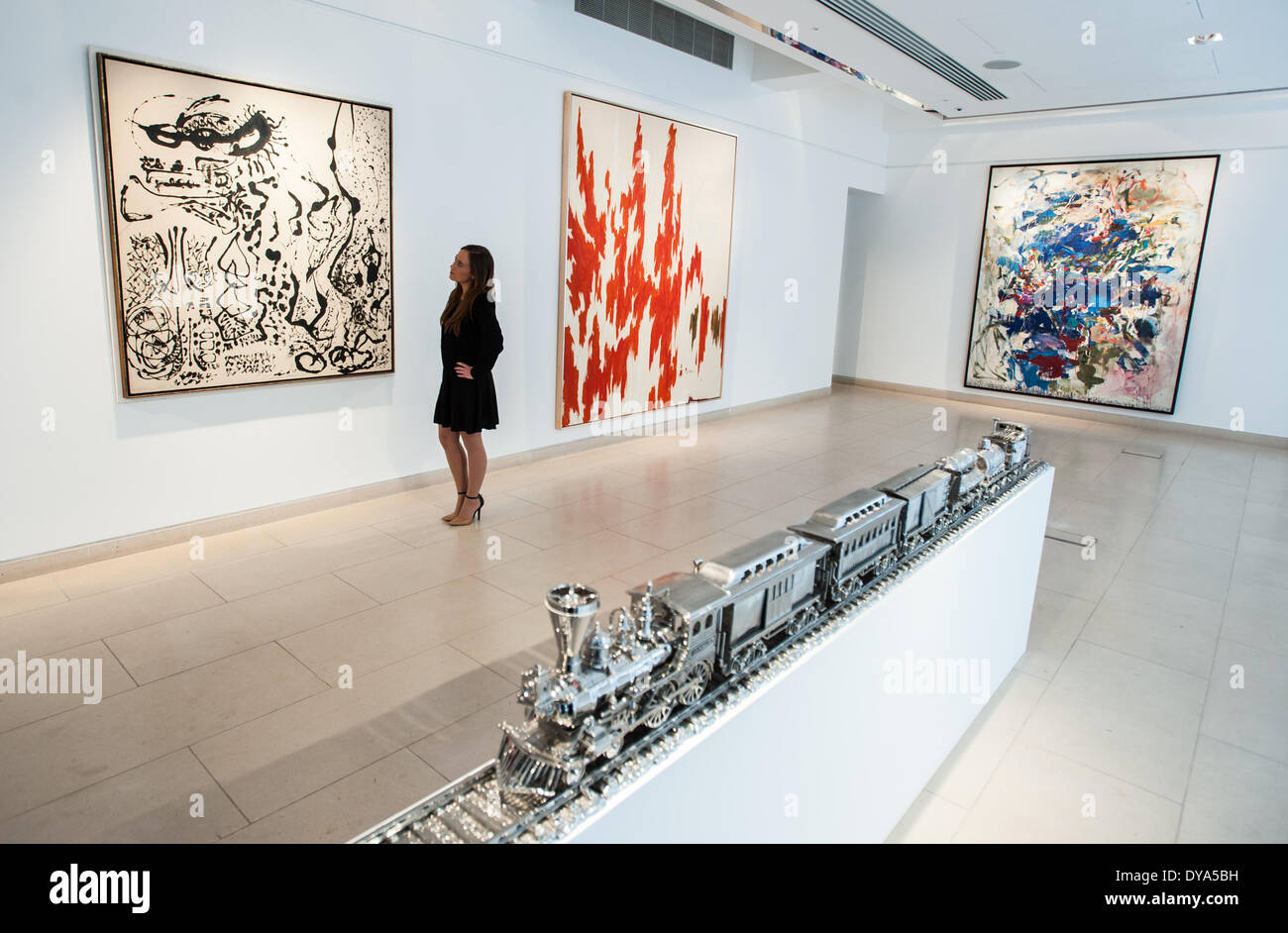 London, Regno Unito - 11 Aprile 2014: una Christie's dipendente guarda al ''elegante signora' da Jackson Pollock (L) e PH-1033' da Clyfford ancora (R) durante l'anteprima dell'Post-War e arte contemporanea vendita serale che si svolgerà a New York il 13 maggio. Credito: Piero Cruciatti/Alamy Live News Foto Stock