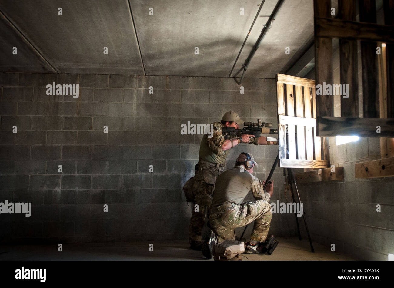 Un cecchino dalla US Army 7 Forze Speciali gruppo fa un adeguamento a un treppiede mentre il suo compagno di squadra identifica il suo bersaglio dall'interno di un edificio durante il cecchino USASOC concorrenza Marzo 26, 2014 a Fort Bragg, N.C. Foto Stock