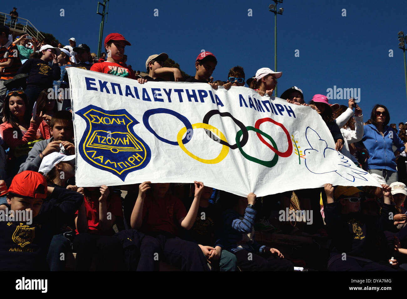 Atene,GRECE-aprile 11: degli studenti di una scuola privata di tenere un banner con i simboli del Olympiv giochi su it.Migliaia di studenti provenienti da tutto il paese hanno partecipato al quarto programma panellenica "Olympic istruzione giorno' presso il vecchio stadio Olimpico dove hanno tentato il Guiness dei primati nella formazione di un enorme colomba con un olivo ramo utilizzando navi di carta sul 11 aprile 2014 ad Atene, in Grecia. (Foto di George Panagakis/ Pacifico Premere) Foto Stock