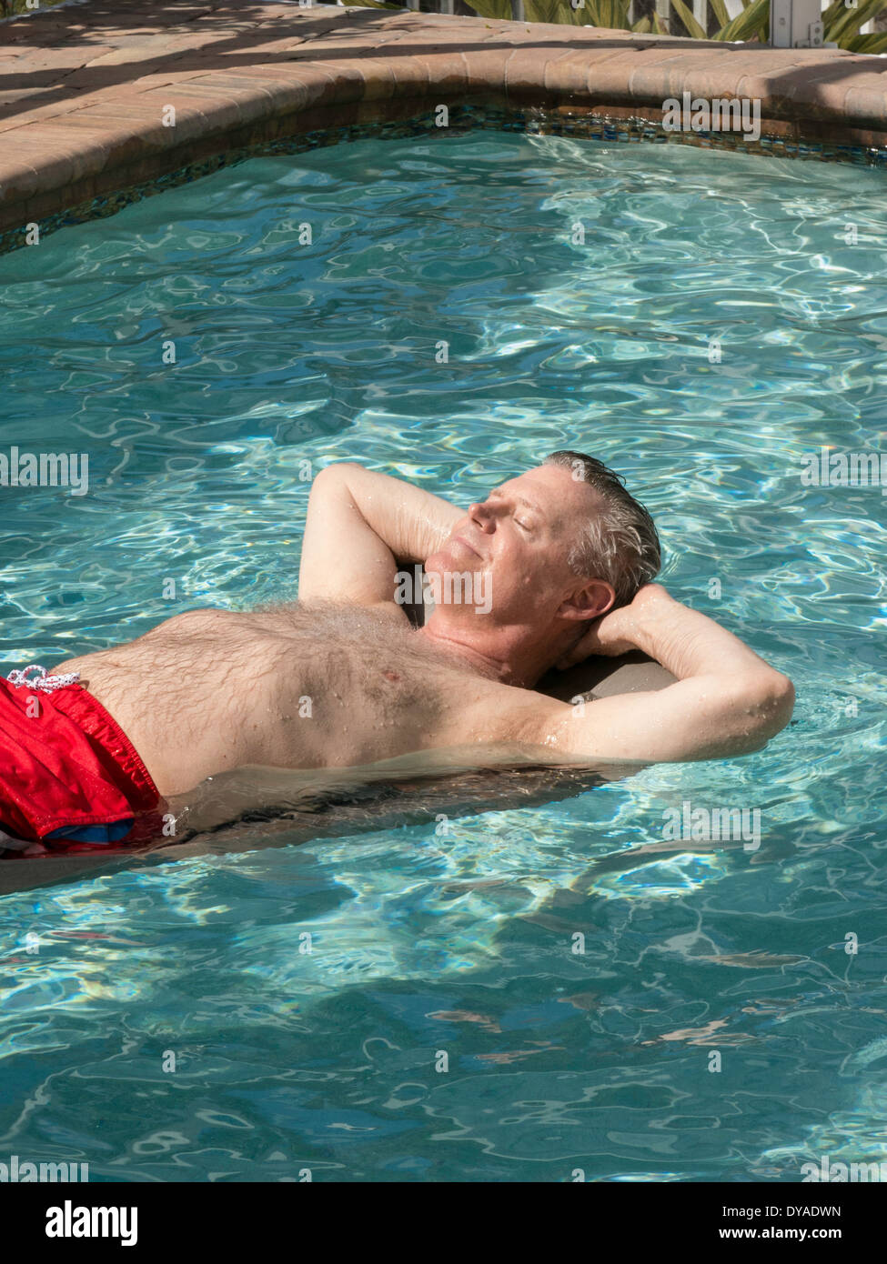 Uomo maturo di oziare in piscina, Punta Gorda, FL Foto Stock