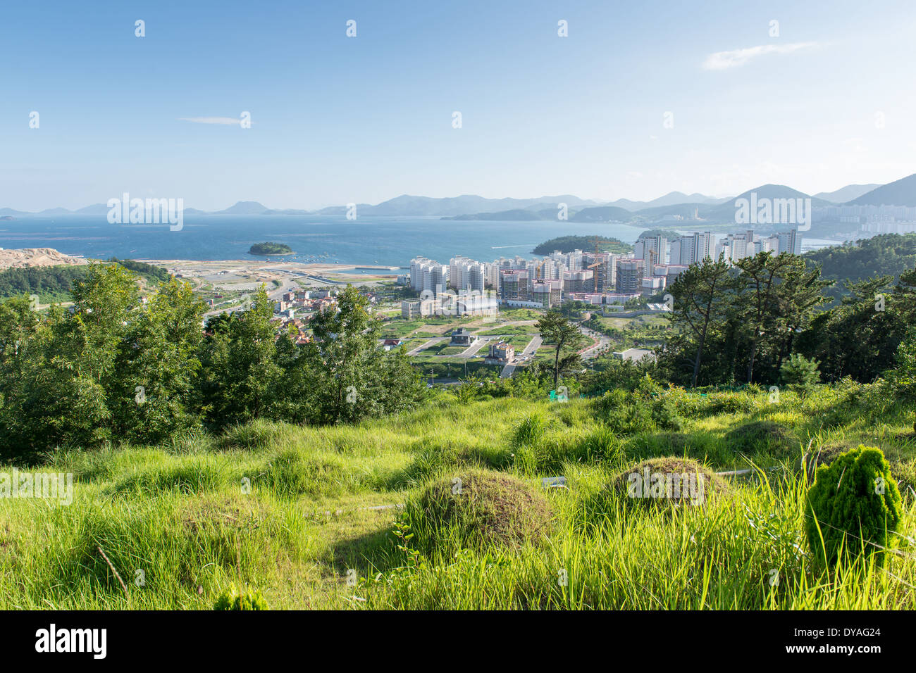 Panorama di Yeosu in Corea del sud come si vede dalle montagne circostanti con la foresta, oceano e alloggiamento sito in costruzione Foto Stock