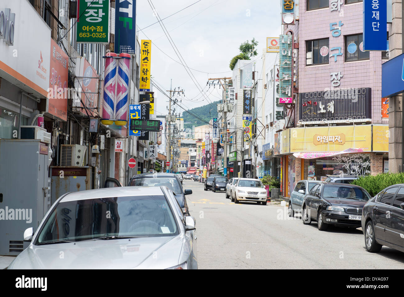 Un vuoto che la strada di Yeosu, corea del sud con auto, negozi e piccoli edifici Foto Stock