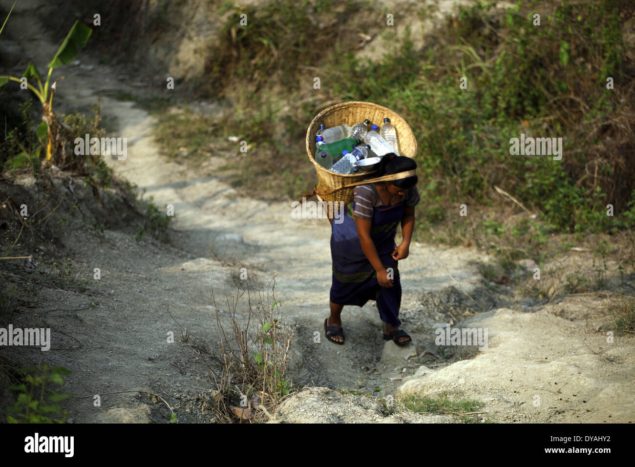 Dacca in Bangladesh. Decimo Apr, 2014. Donne e ragazze stanno andando a raccogliere acqua dalla lunga distanza. Durante la calda stagione estiva comunità indigena al quartiere Bandorban rivolta verso il problema dell'acqua. Ci sono circa 35 piccoli gruppi di comunità indigene in Bangladesh che copre circa il due per cento del totale della popolazione sono state vivendo in diverse tasche delle zone collinari e di pianura alcune terre del paese. Credito: Zakir Hossain Chowdhury/NurPhoto/ZUMAPRESS.com/Alamy Live News Foto Stock
