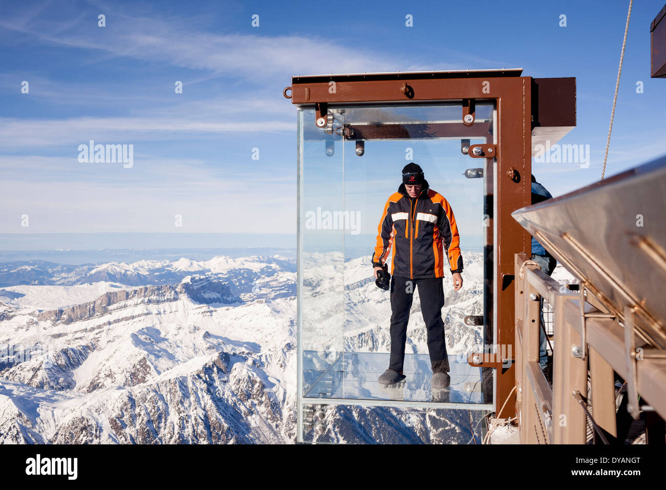 Un turista si erge nel 'Step nel vuoto' box di vetro sulla Aiguille du Midi (3842m) mountain top sopra Chamonix Monte Bianco Foto Stock