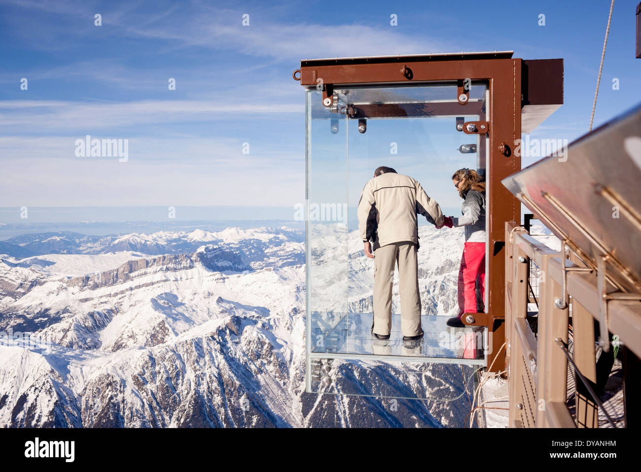 Un turista si erge nel 'Step nel vuoto' box di vetro sulla Aiguille du Midi (3842m) mountain top sopra Chamonix Monte Bianco Foto Stock