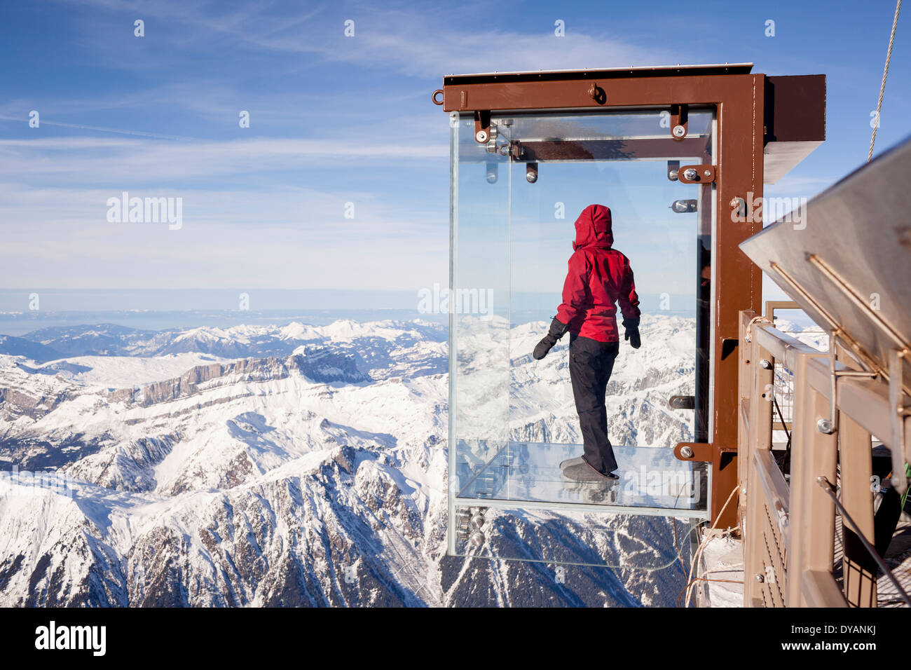 Un turista si erge nel 'Step nel vuoto' box di vetro sulla Aiguille du Midi (3842m) mountain top sopra Chamonix Monte Bianco Foto Stock