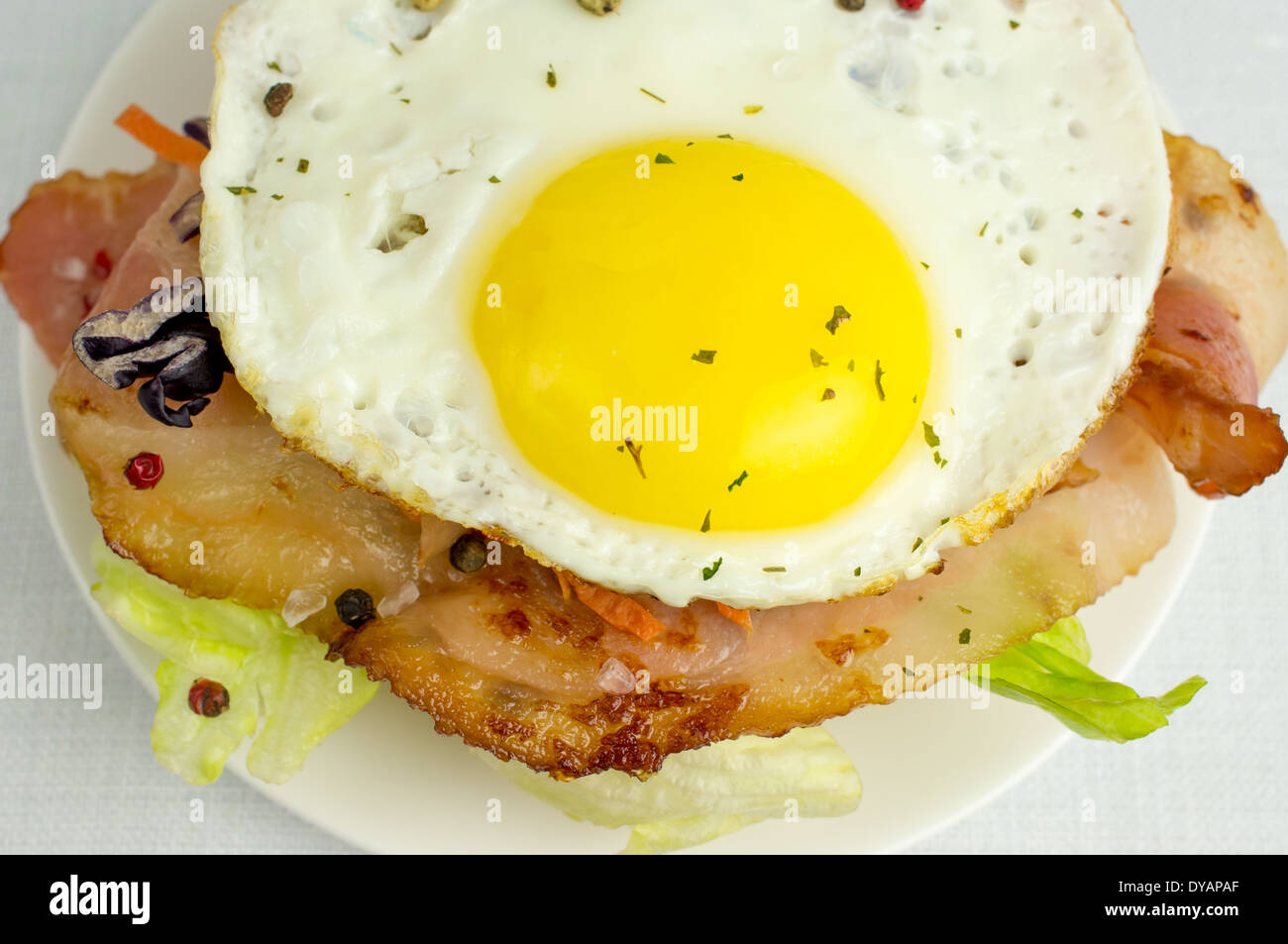 Burger con uova fritte e insalata di pancetta Foto Stock