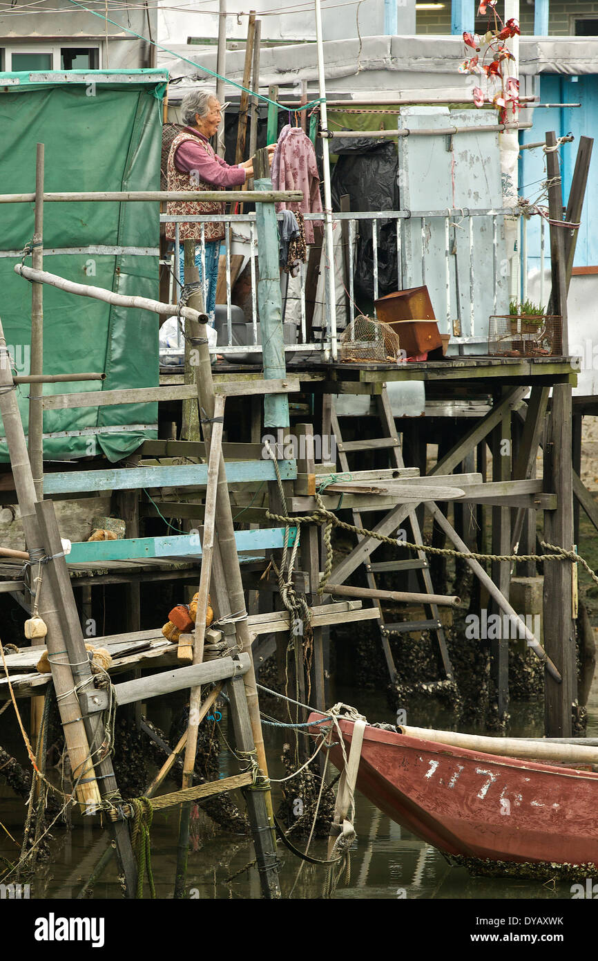 Anziani donna cinese al di fuori della sua casa su palafitte in 'Tai O' Cinese tradizionale villaggio di pescatori sull'Isola di Lantau, Hong Kong. Foto Stock