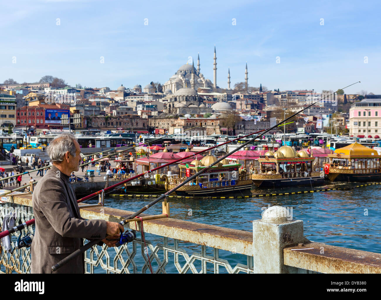 Il pescatore sul Ponte Galata con il quartiere Eminonu waterfront dietro, Istanbul, Turchia Foto Stock