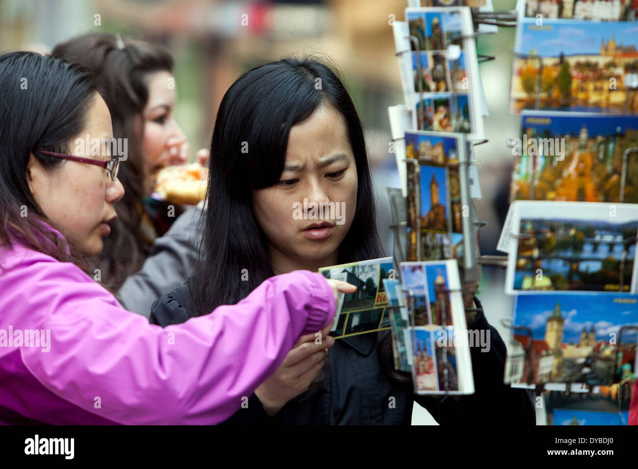 Selezione di souvenir presso le bancarelle Praga turisti shopping Repubblica Ceca turismo donne cartoline Foto Stock