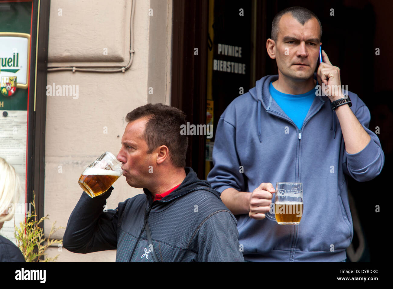 Due uomini che bevono birra fuori da un bar su una strada, la città vecchia di Praga Repubblica Ceca vita quotidiana Foto Stock