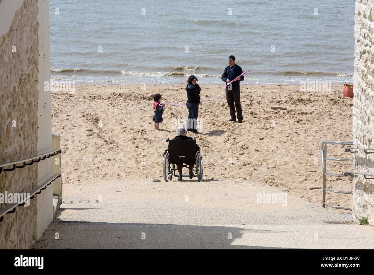 Disabilitato vecchia signora famiglia spiaggia sedia a rotelle bloccato Foto Stock