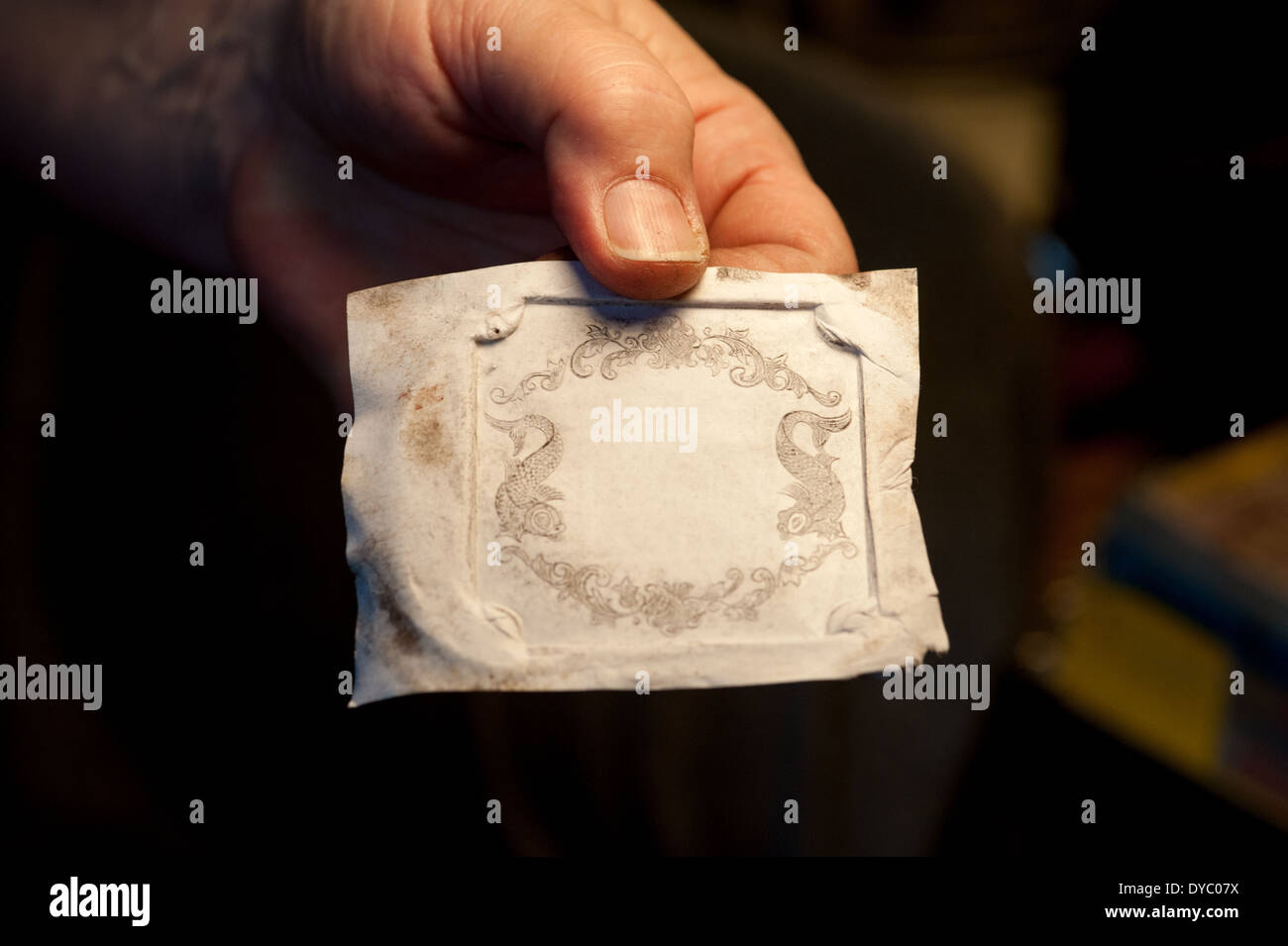 Donna che mantiene un pattern sul panno per essere stampati su argento per incisione in argento Foto Stock