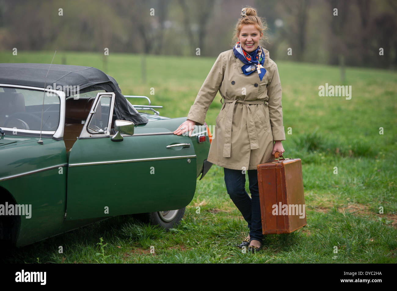 Donna con pranzo sacchi sul viaggio accanto a classic british auto sportiva Foto Stock
