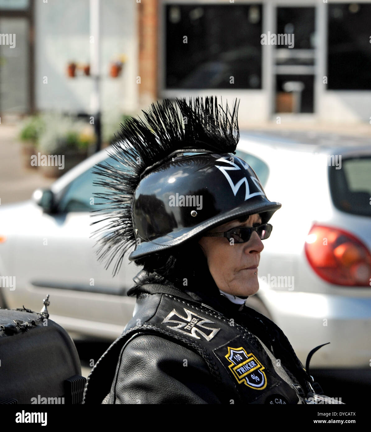 Femmina appassionato di motocicletta indossando il casco con capelli mohicano sulla sommità e pelli nere REGNO UNITO Foto Stock