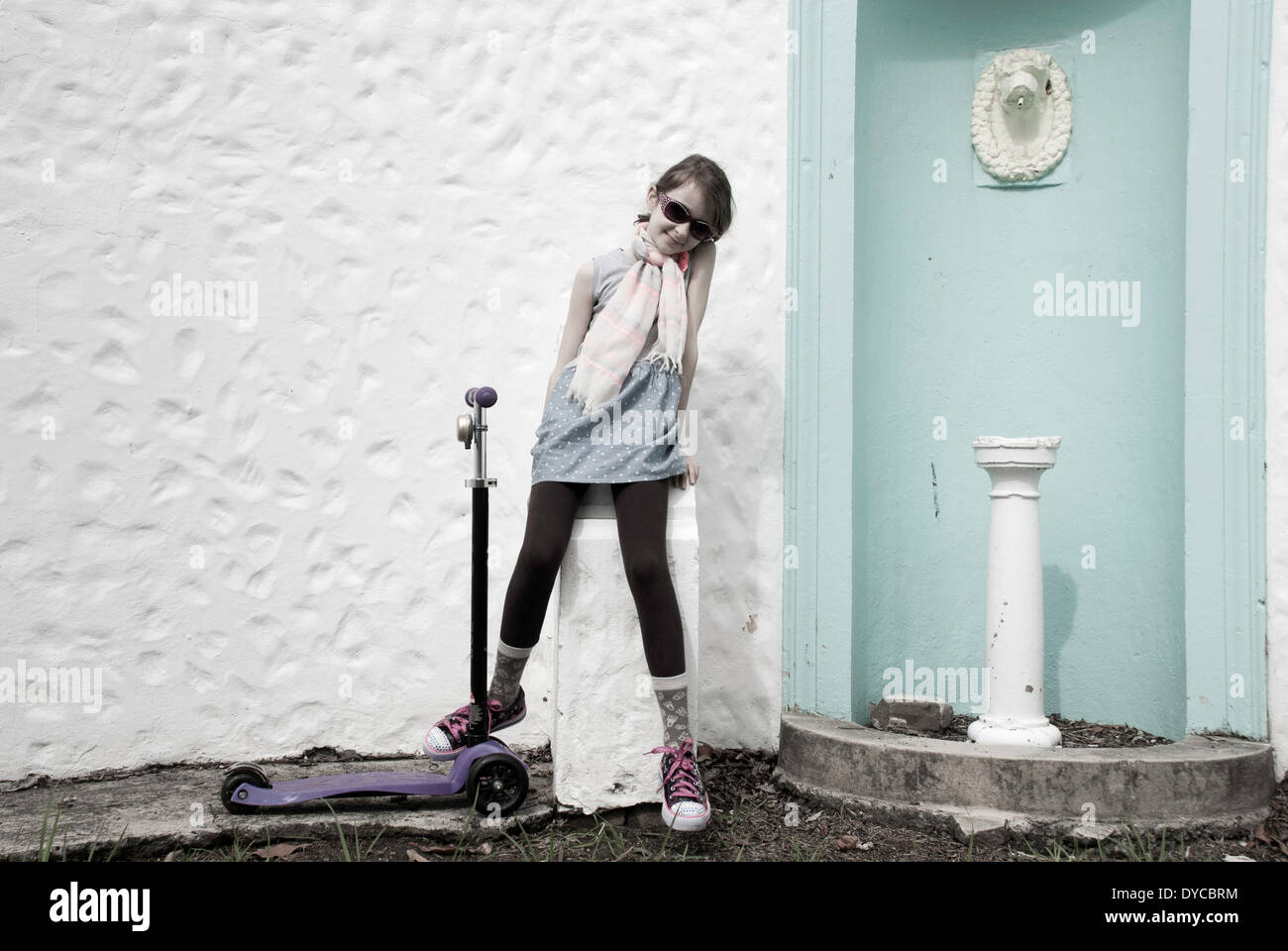 Una giovane ragazza in posa accanto al suo scooter. Foto Stock
