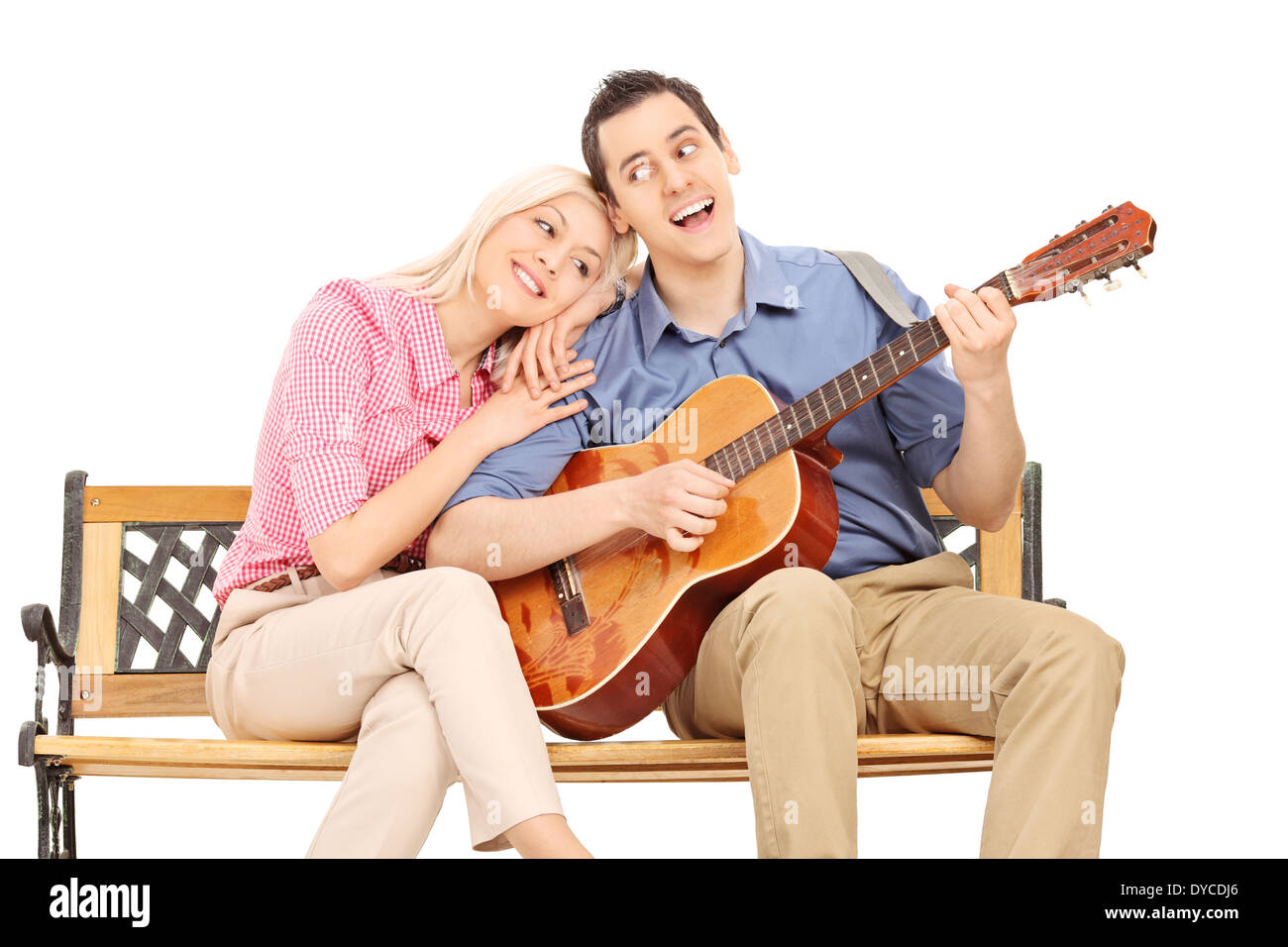 Giovane ragazzo a suonare la chitarra alla sua ragazza seduto sul banco di lavoro Foto Stock