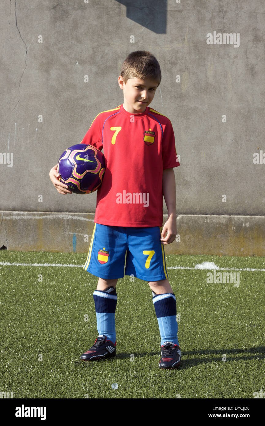 Ritratto di giovane maschio tenendo una squadra di calcio spagnolo da indossare kit calcio. Foto Stock