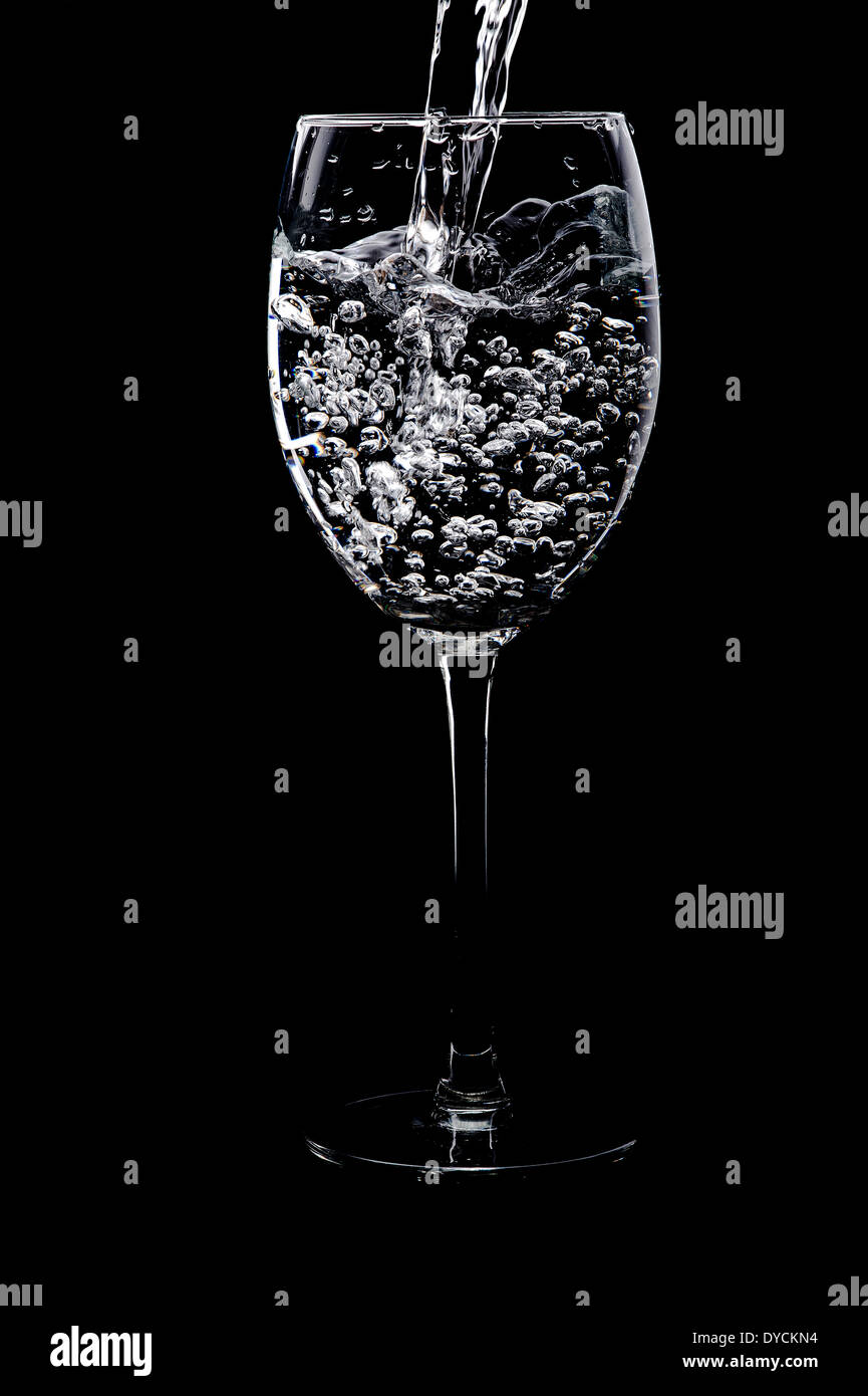 L'acqua versata in un bicchiere. Foto Stock