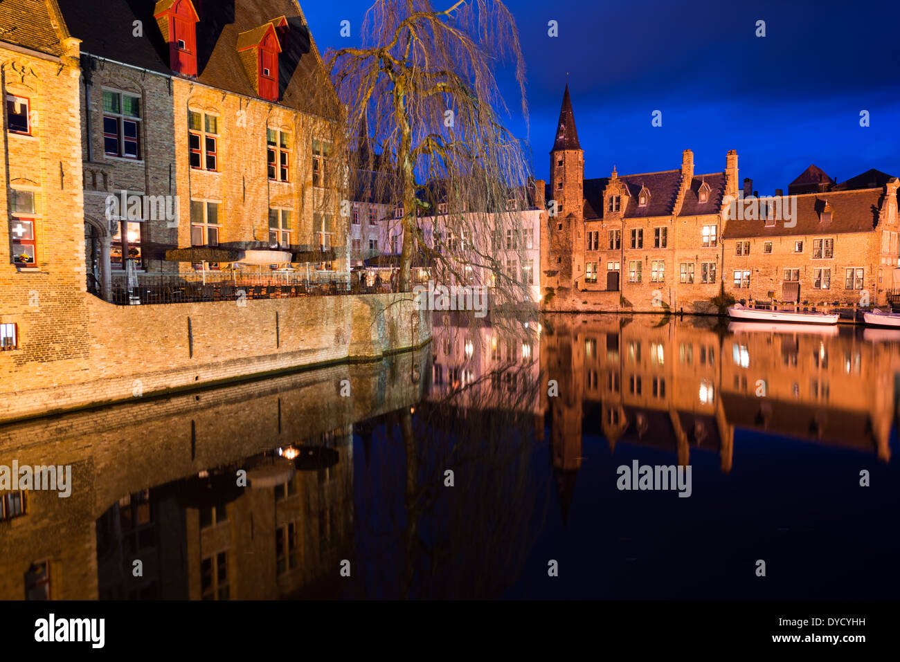 Canali di Bruges edifici storici luce serale Bruges Belgio // BRUGES, Belgio - la rete medioevale di canali di Bruges riflette la luce della sera, evidenziando il ruolo storico della città come importante porto commerciale. Conosciuti come la "Venezia del Nord", questi corsi d'acqua una volta collegavano Bruges al Mare del Nord attraverso il canale di Zwin fino alla sua insabbiamento nel XV secolo. I canali conservati si snodano attraverso il sito patrimonio dell'umanità dell'UNESCO, fiancheggiati da edifici secolari che mostrano il patrimonio commerciale della città. Foto Stock