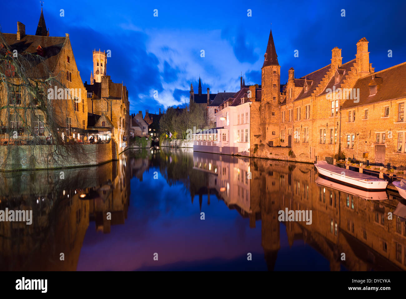 Bruges Canals Medieval Architecture Belgio // BRUGES, Belgio - la rete medioevale dei canali di Bruges riflette la luce della sera, evidenziando il ruolo storico della città come importante porto commerciale. Conosciuti come la "Venezia del Nord", questi corsi d'acqua una volta collegavano Bruges al Mare del Nord attraverso il canale di Zwin fino alla sua insabbiamento nel XV secolo. I canali conservati si snodano attraverso il sito patrimonio dell'umanità dell'UNESCO, fiancheggiati da edifici secolari che mostrano il patrimonio commerciale della città. Foto Stock