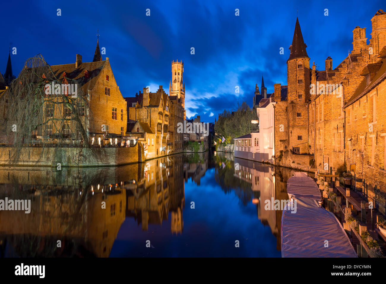 Canali di Bruges architettura medievale Bruges Belgio // BRUGES, Belgio - la rete medioevale dei canali di Bruges riflette la luce della sera, evidenziando il ruolo storico della città come importante porto commerciale. Conosciuti come la "Venezia del Nord", questi corsi d'acqua una volta collegavano Bruges al Mare del Nord attraverso il canale di Zwin fino alla sua insabbiamento nel XV secolo. I canali conservati si snodano attraverso il sito patrimonio dell'umanità dell'UNESCO, fiancheggiati da edifici secolari che mostrano il patrimonio commerciale della città. Foto Stock