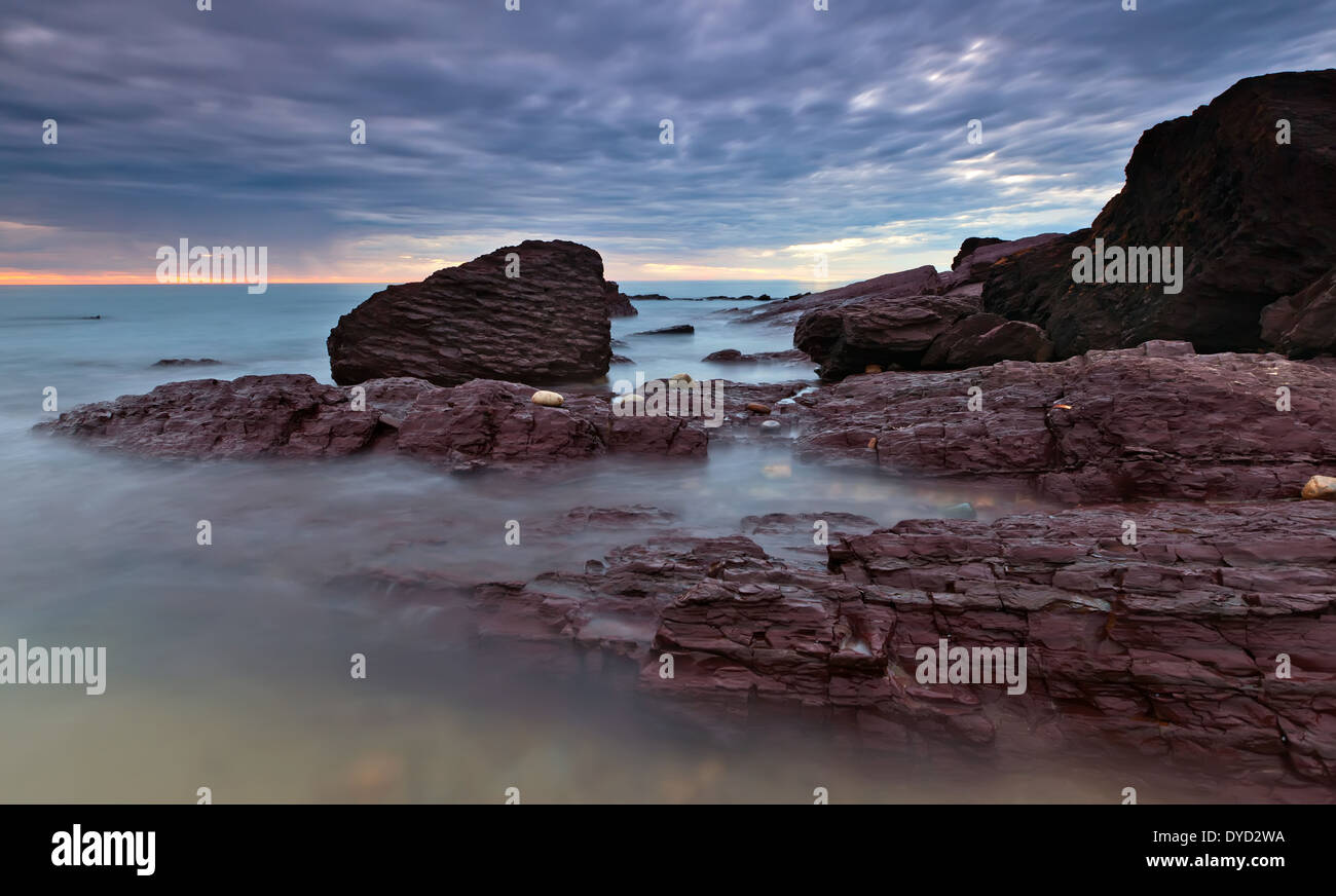 Sunset Coast seascape paesaggi marini rocky ondata di marea costiere oceaniche acqua onde di movimento surf rock pool pool pool di roccia geologia pebbl Foto Stock