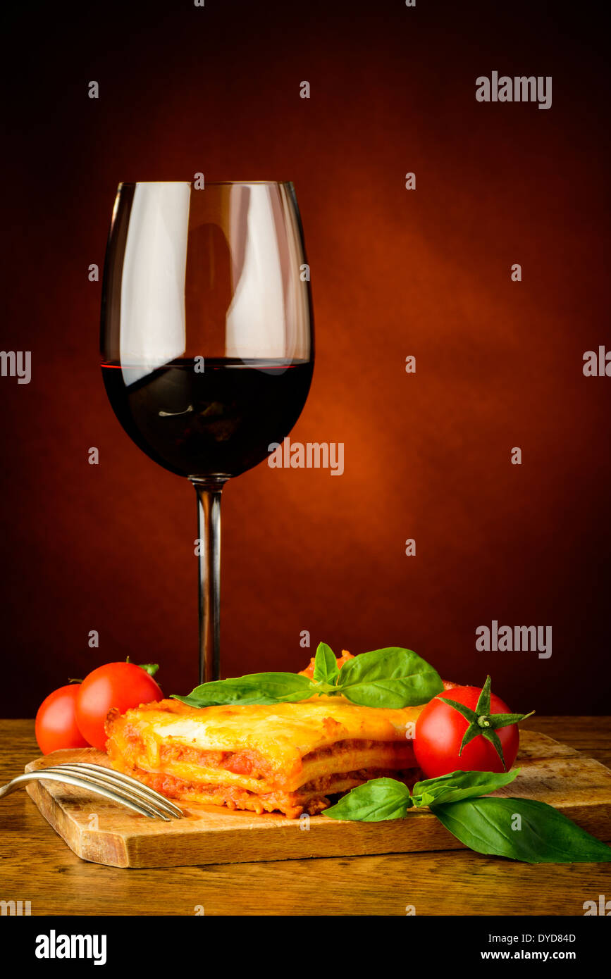 Lasagne tradizionali la cena con un bicchiere di vino rosso Foto Stock