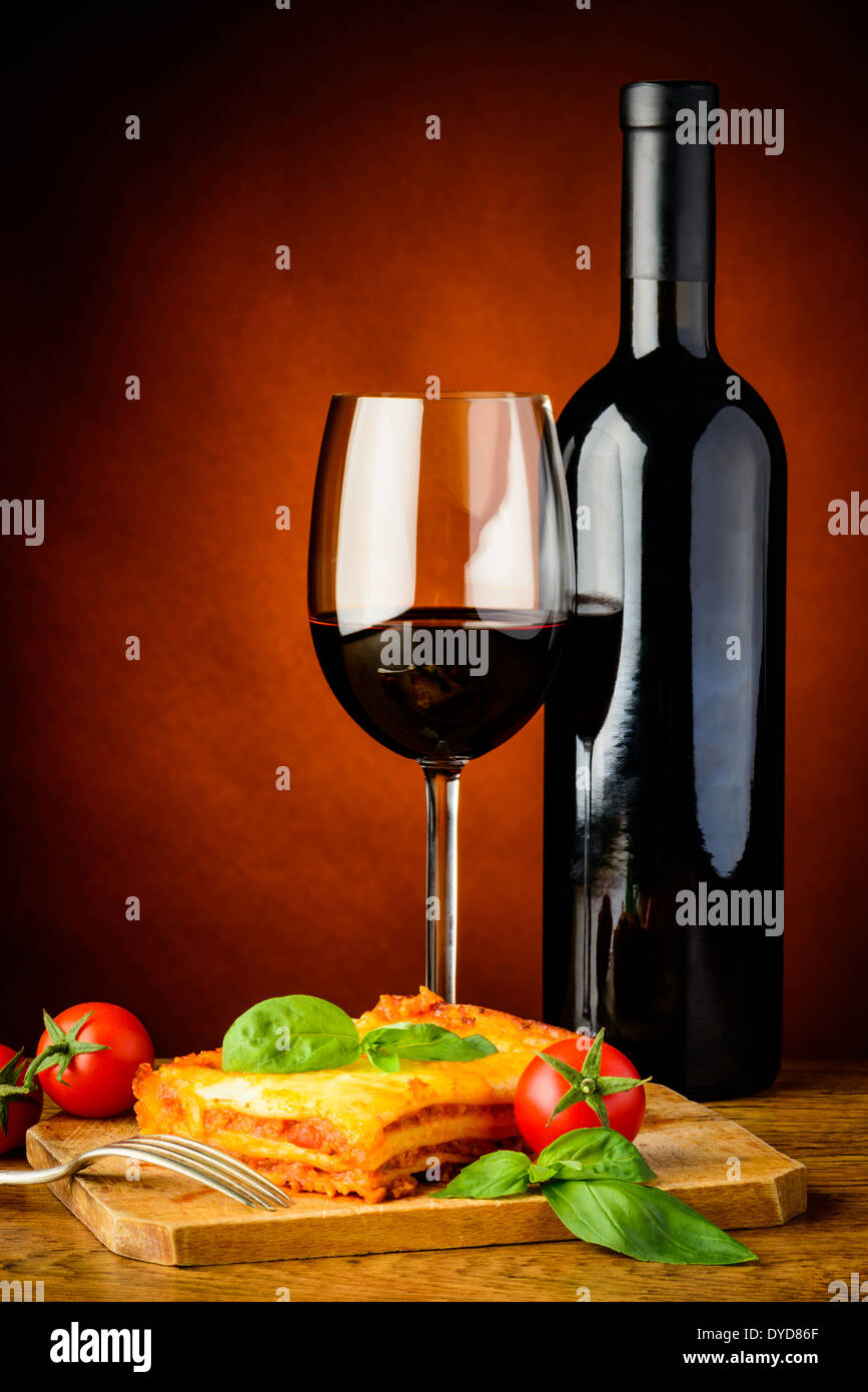 Lasagne tradizionali pasto bolognese con vetro e una bottiglia di vino rosso Foto Stock