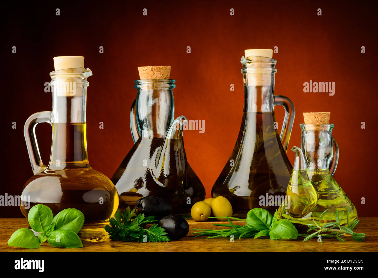 Diverse bottiglie di infuso di olio di oliva con erbette verdi Foto Stock