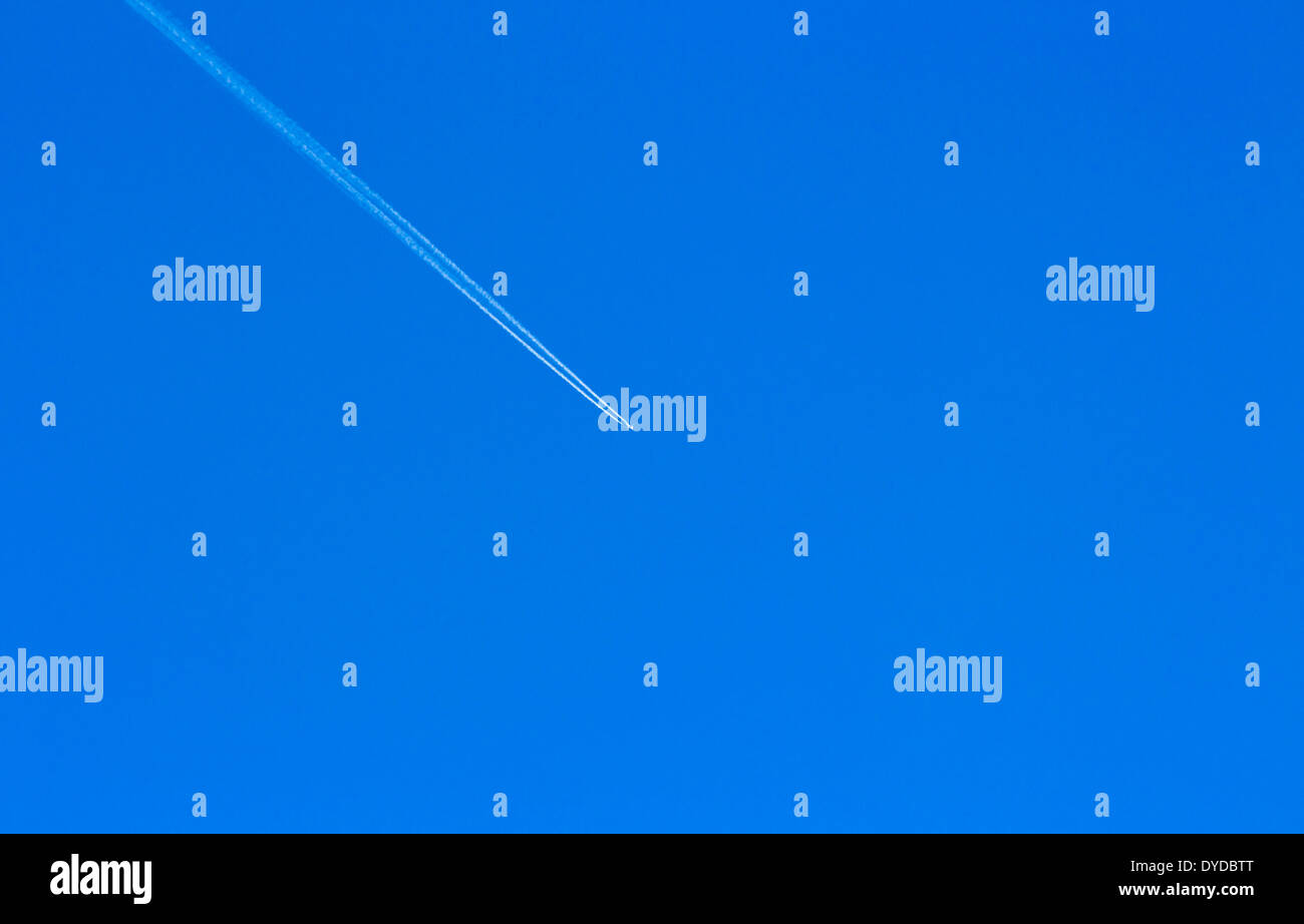 Un getto piano elevato overhead contro un cielo blu. Foto Stock