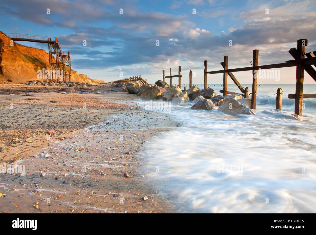 Happisburgh la spiaggia e il mare abbandonati difese alla prima luce sulla costa di Norfolk. Foto Stock