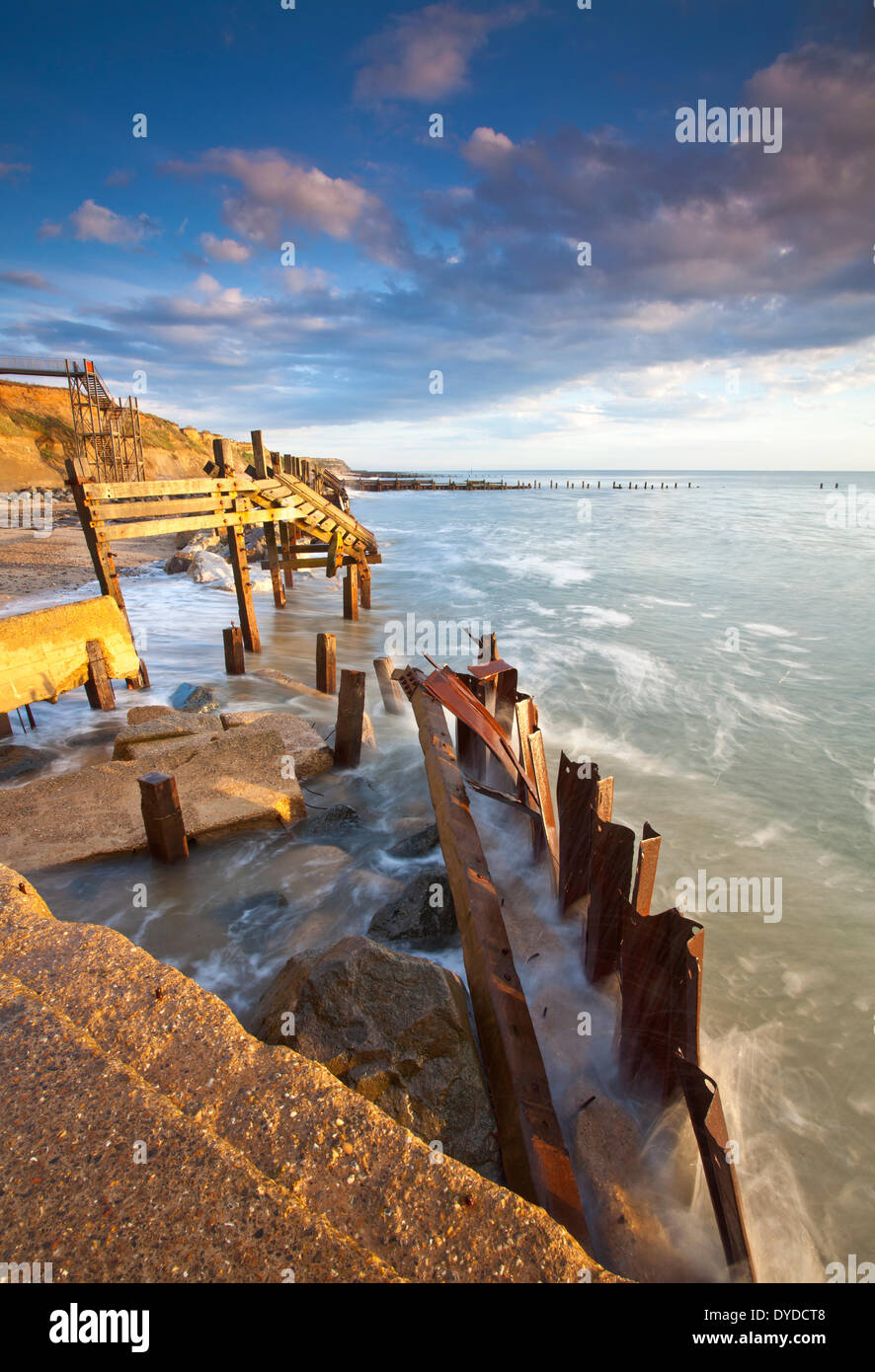Happisburgh la spiaggia e il mare abbandonati difese alla prima luce sulla costa di Norfolk. Foto Stock
