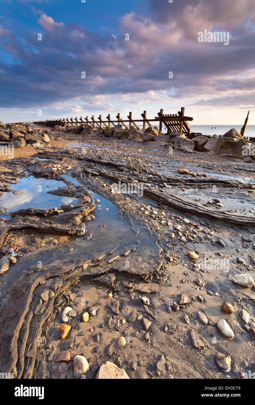 Happisburgh la spiaggia e il mare abbandonati difese alla prima luce sulla costa di Norfolk. Foto Stock