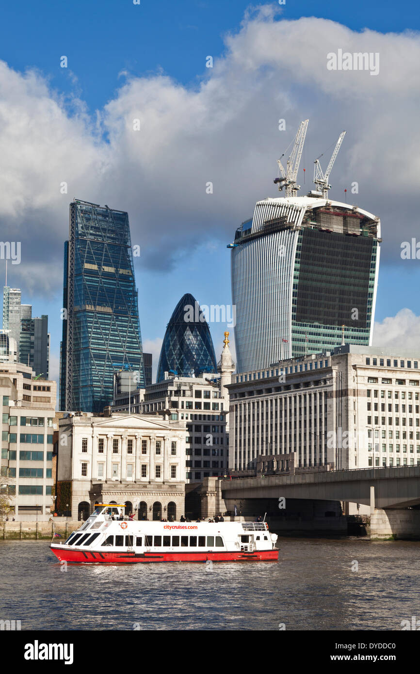 Un battello da diporto sul Tamigi passa edifici nel centro finanziario di Londra. Foto Stock