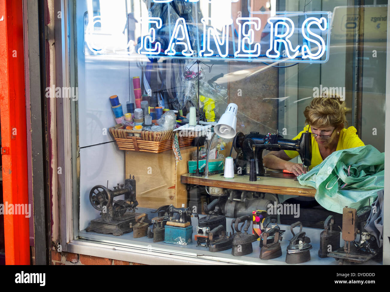 Una donna cuce a pulitori a Manhattan. Foto Stock